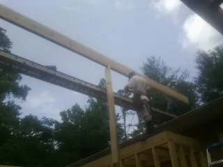 Carpenter setting a ridge beam over a new addition frame — Ice Dam Removal by Roofing Brothers in Patricksburg