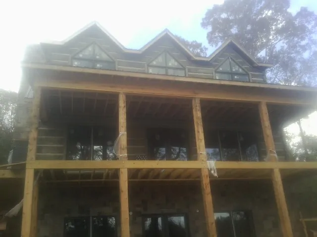 Dormers and porch framing on a large log home under construction — Roof Coating work by our crew in Patricksburg