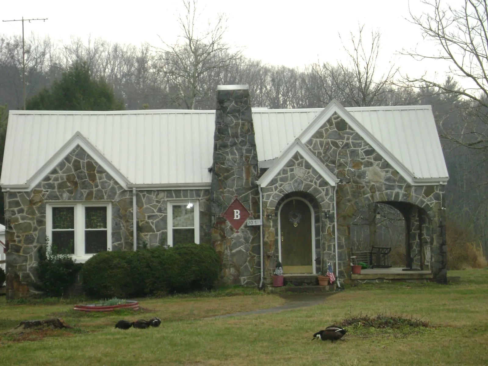 White metal roof on a stone cottage with steep gables in Patricksburg